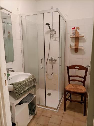 La salle de bains est pourvue d'une douche et d'une chaise en bois. dans l'établissement Domaine de l'Etangsort, à Courdemanche