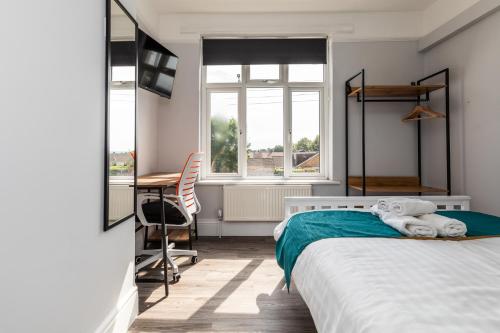 a bedroom with a bed and a desk and window at Dove Court Travel Lodge 3 - First Floor Ensuite in Bristol