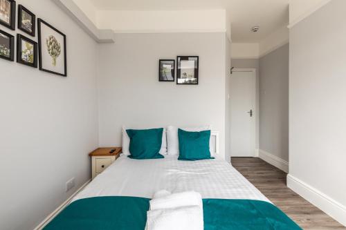 a bedroom with a large bed with blue pillows at Dove Court Travel Lodge 3 - First Floor Ensuite in Bristol