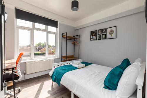 a bedroom with a bed and a desk and a window at Dove Court Travel Lodge 3 - First Floor Ensuite in Bristol