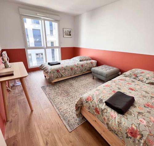 une chambre avec deux lits, une table et un bureau dans l'établissement Charming apartment with 3 bedrooms and terrace, à Saint-Ouen
