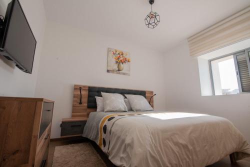 une chambre avec un lit et une télévision à écran plat dans l'établissement Blu paradise,a ray of sunshine between sea & pool, à Agadir