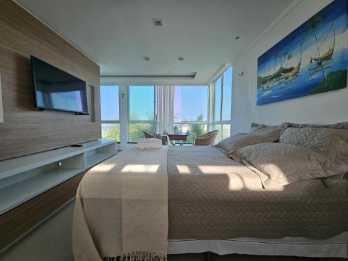 a bedroom with a large bed and a flat screen tv at Malie Hotel in Águas Belas