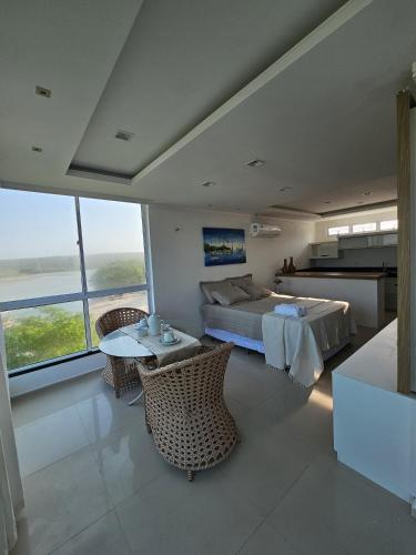 a bedroom with a bed and a table and chairs at Malie Hotel in Águas Belas