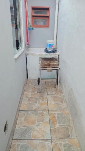 a room with a table with a window and a stone floor at Chalé Ubatuba pertinho do mar in Ubatuba