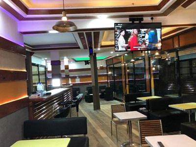 a restaurant with tables and chairs and a tv at Grand studio climatisé 5' mer accès Dakar in Dakar