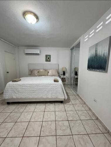ein Schlafzimmer mit einem Bett und einem gefliesten Boden in der Unterkunft Shalex House 4 in Campamento Pinones