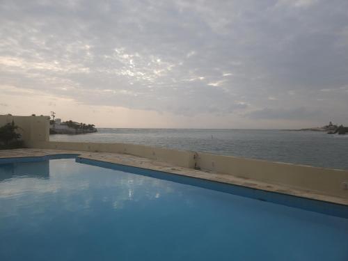 a swimming pool with the ocean in the background at Malie Hotel in Águas Belas