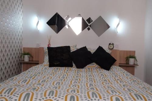 - une chambre avec un grand lit et des oreillers noirs dans l'établissement Cosy T2 au centre historique de la ville Toulon, à Toulon