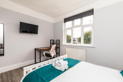 a white bedroom with a bed and a television at Dove Court Travel Lodge 4 - First Floor Ensuite in Bristol