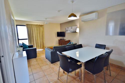 een kamer met een tafel en stoelen en een woonkamer bij Riverview Holiday Apartment 67 - Kalbarri WA in Kalbarri