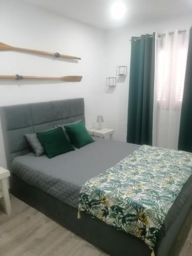 a bedroom with a bed with green pillows at Casa Avós D'Ouro - Barqueiros, Mesão Frio, Douro in Mesão Frio