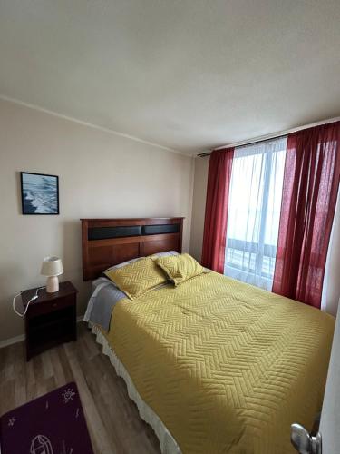 トメにあるTomé, Departamento vista al mar, playa Bellavistaのベッドルーム1室(黄色いベッド1台、窓付)