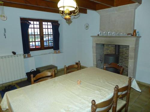 une pièce avec une table, des chaises et une cheminée dans l'établissement Gîte de 160m2 au coeur de la nature, à Courpignac