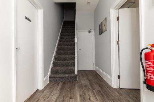 a staircase in a home with white walls and wood floors at Dove Court Travel Lodge 5 - First Floor Ensuite in Bristol