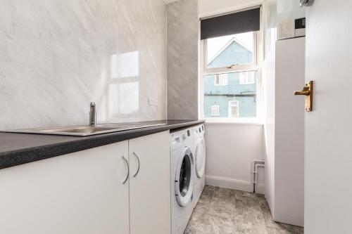 a kitchen with a sink and a washing machine at Dove Court Travel Lodge 5 - First Floor Ensuite in Bristol