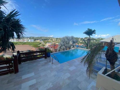 uma piscina em um resort com palmeiras em Deluxe Modern 1BR I Pool with Amazing Sea Views I Ideal Location em Gros Islet