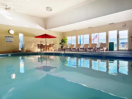 a swimming pool with a table and chairs and an umbrella at Econo Lodge Wausau - Rothschild in Rothschild