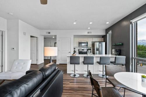 a living room with a black leather couch and a kitchen at Gorgeous Central City 2BD 2BA in Salt Lake City