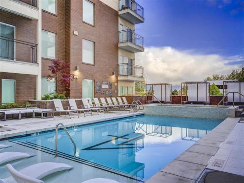 a swimming pool with chairs and a building at Gorgeous Central City 2BD 2BA in Salt Lake City
