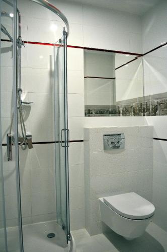 a bathroom with a toilet and a glass shower at 3 City Hostel in Gdańsk