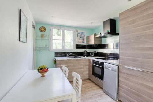 une cuisine avec une table blanche et un comptoir blanc dans l'établissement Time of travel, à Rueil-Malmaison