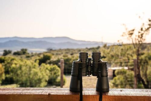 two black guns sitting on a wooden fence at Stylish Country Home with Hot Tub and Amazing Views on 40 Acres in Ranchita