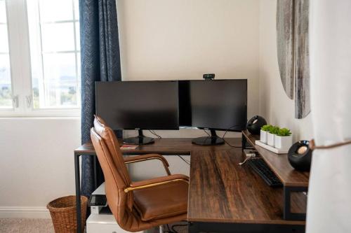 a desk with a computer monitor and a chair at Stylish Country Home with Hot Tub and Amazing Views on 40 Acres in Ranchita