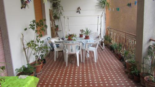a table and chairs on a balcony with plants at Bed & Breakfast Alice in Valderice