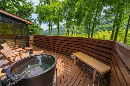 a wooden deck with a tub and a bench on it at VILLA ATAMI -Maruta- in Atami