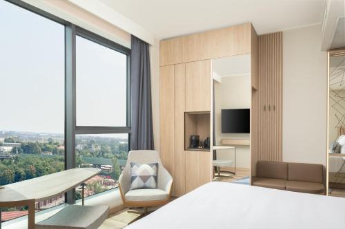 a bedroom with a bed and a table and a chair at Courtyard by Marriott Milano Linate in Milan