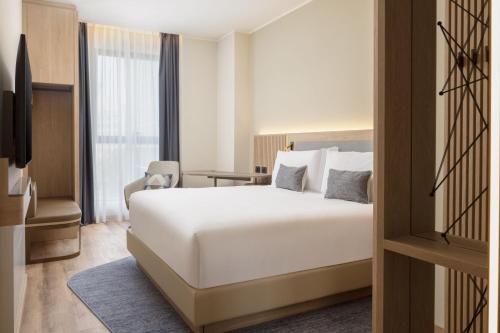 a hotel room with a bed and a window at Courtyard by Marriott Milano Linate in Milan