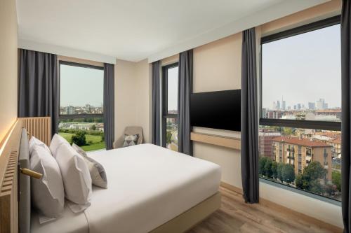 a bedroom with a bed and a large window at Courtyard by Marriott Milano Linate in Milan