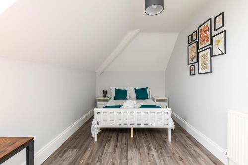 a bedroom with a white bed with blue pillows at Dove Court Travel Lodge 7 - Top Floor Double Bedroom in Bristol