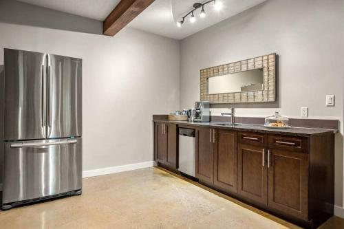 a kitchen with a stainless steel refrigerator and a sink at Escape to the Rockies but near Calgary Includes Free Parking and Banff Entry in Calgary