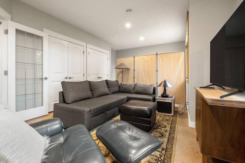 a living room with a couch and a television at Escape to the Rockies but near Calgary Includes Free Parking and Banff Entry in Calgary