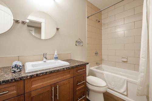 a bathroom with a sink and a toilet and a tub at Escape to the Rockies but near Calgary Includes Free Parking and Banff Entry in Calgary