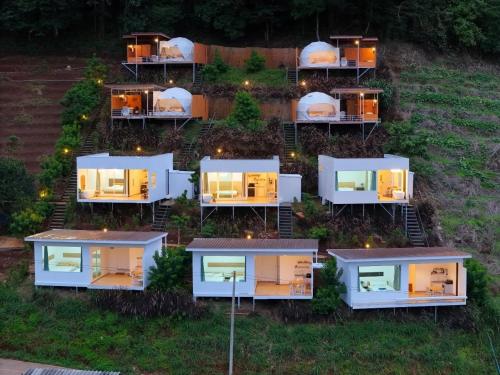 a group of modular homes on a hill at night at มิด้าโฮมสเตย์ม่อนแจ่ม in Mon Jam