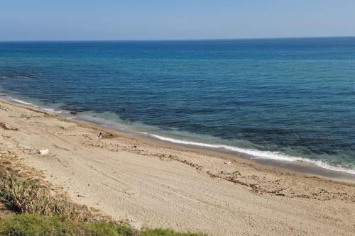a beach with people on the sand and the water at Ardhraubu Villa, Terra Cotta & Very Close to Sea in La Cala de Mijas
