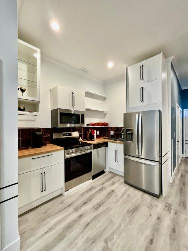 a kitchen with white cabinets and stainless steel appliances at Beautiful Modern Muse with all you need within and around in Soulard