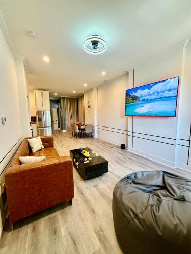a living room with a couch and a tv on a wall at Beautiful Modern Muse with all you need within and around in Soulard