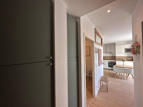 a kitchen and living room with a refrigerator and a table at Appartement LYS aéroport, Eurexpo, Groupama stadium, Arena LDLC in Pusignan