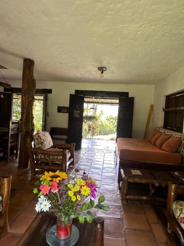 a living room with a couch and flowers on a table at La Villa The View in Pance