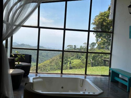 a bath tub in a room with a large window at La Villa The View in Pance