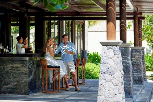 a man and a woman sitting at a bar at Amarterra Villas Resort Bali Nusa Dua, Autograph Collection in Nusa Dua