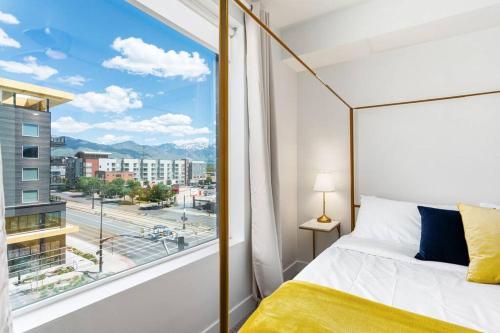 a bedroom with a bed and a large window at Luxury Apt 6th floor - King Bed Gym Prkg Pool NEW in Salt Lake City