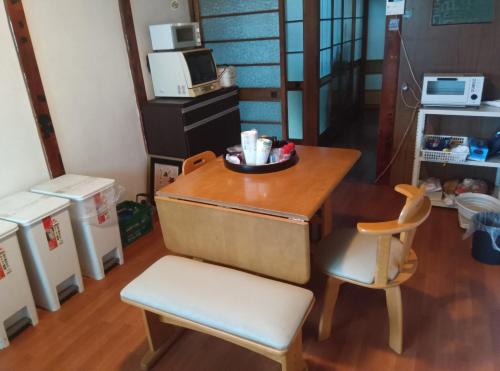 une petite table et une chaise avec une assiette dessus dans l'établissement 民泊M103, à Satte