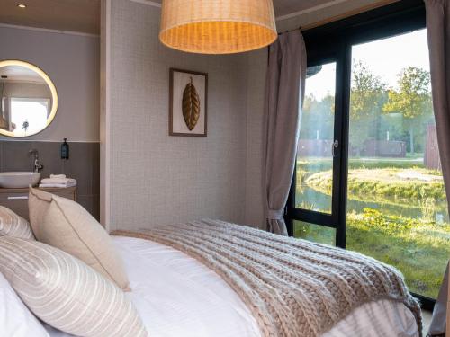a bedroom with a bed and a large window at Modern Bungalow with Nature in Antoing