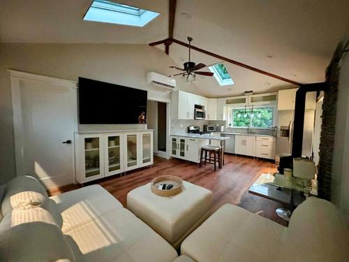 a living room with a white couch and a kitchen at Lovely private home in a serene neighborhood in Totowa