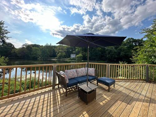 a chair and an umbrella on a deck at Lovely private home in a serene neighborhood in Totowa